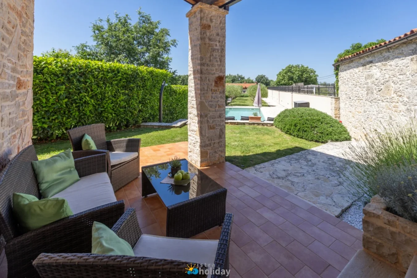 Stone patio with seating and backyard pool