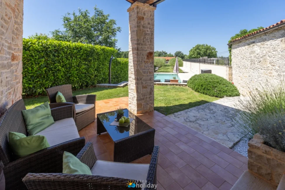 Stone patio with seating and backyard pool