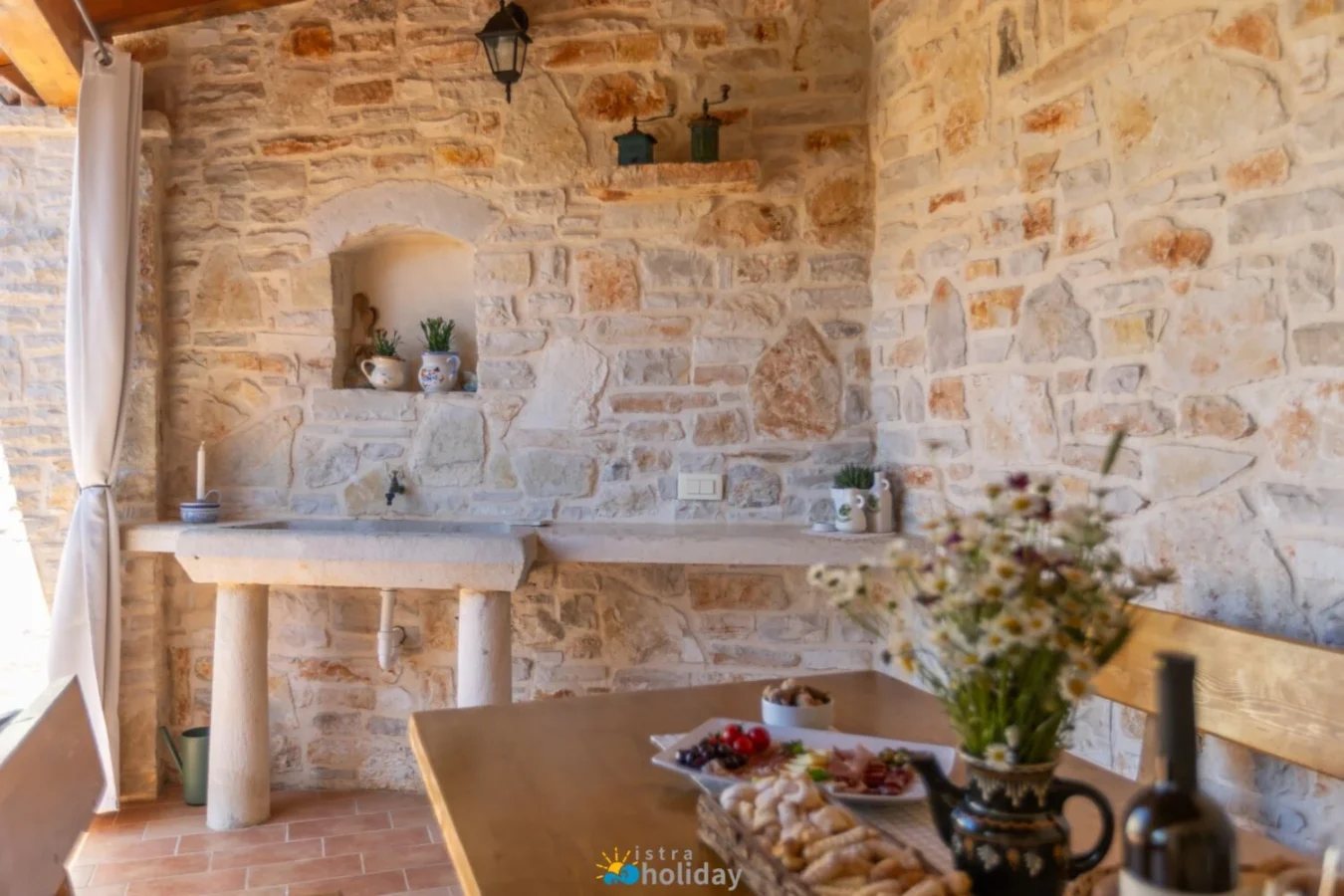 Rustic stone patio kitchen with wooden table