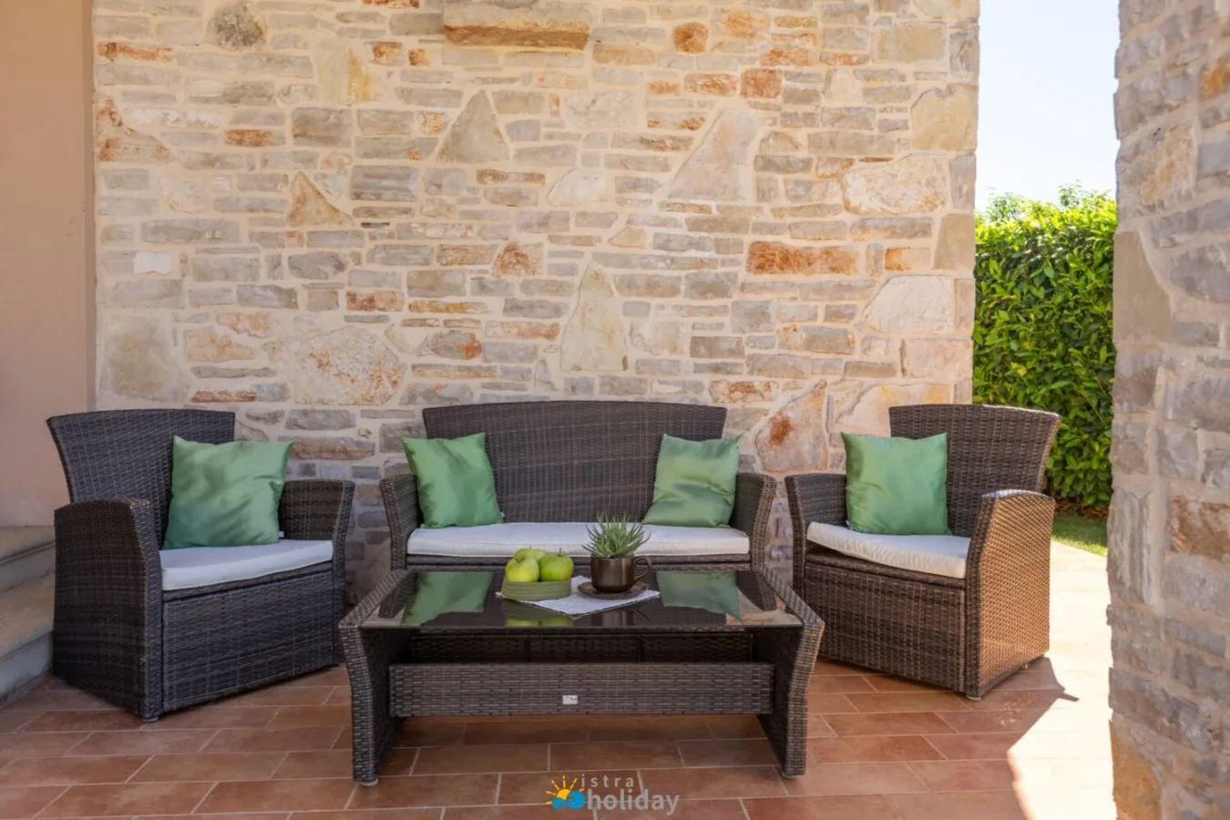 Wicker patio seating with green cushions