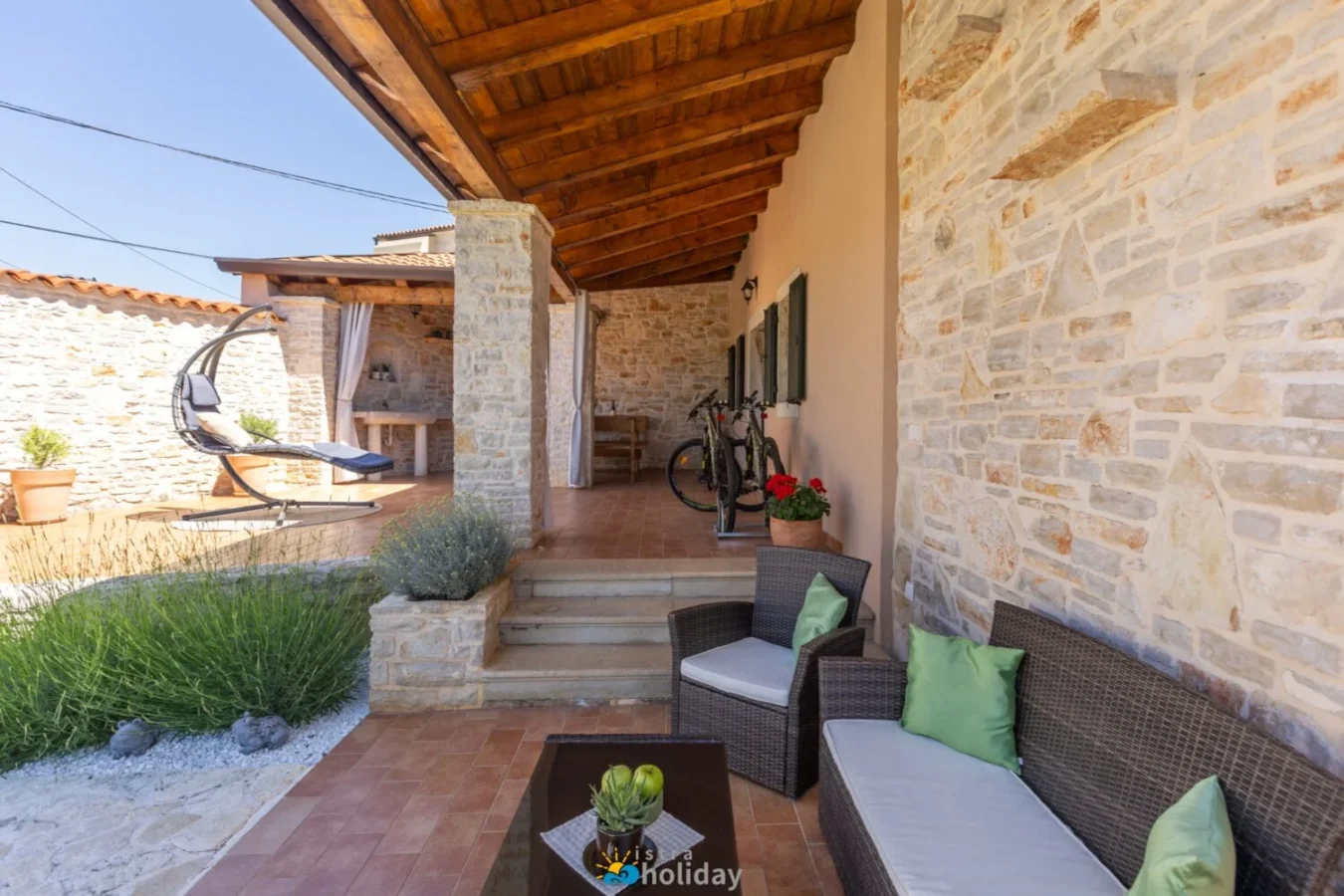 Rustic stone patio with wicker seating and bike