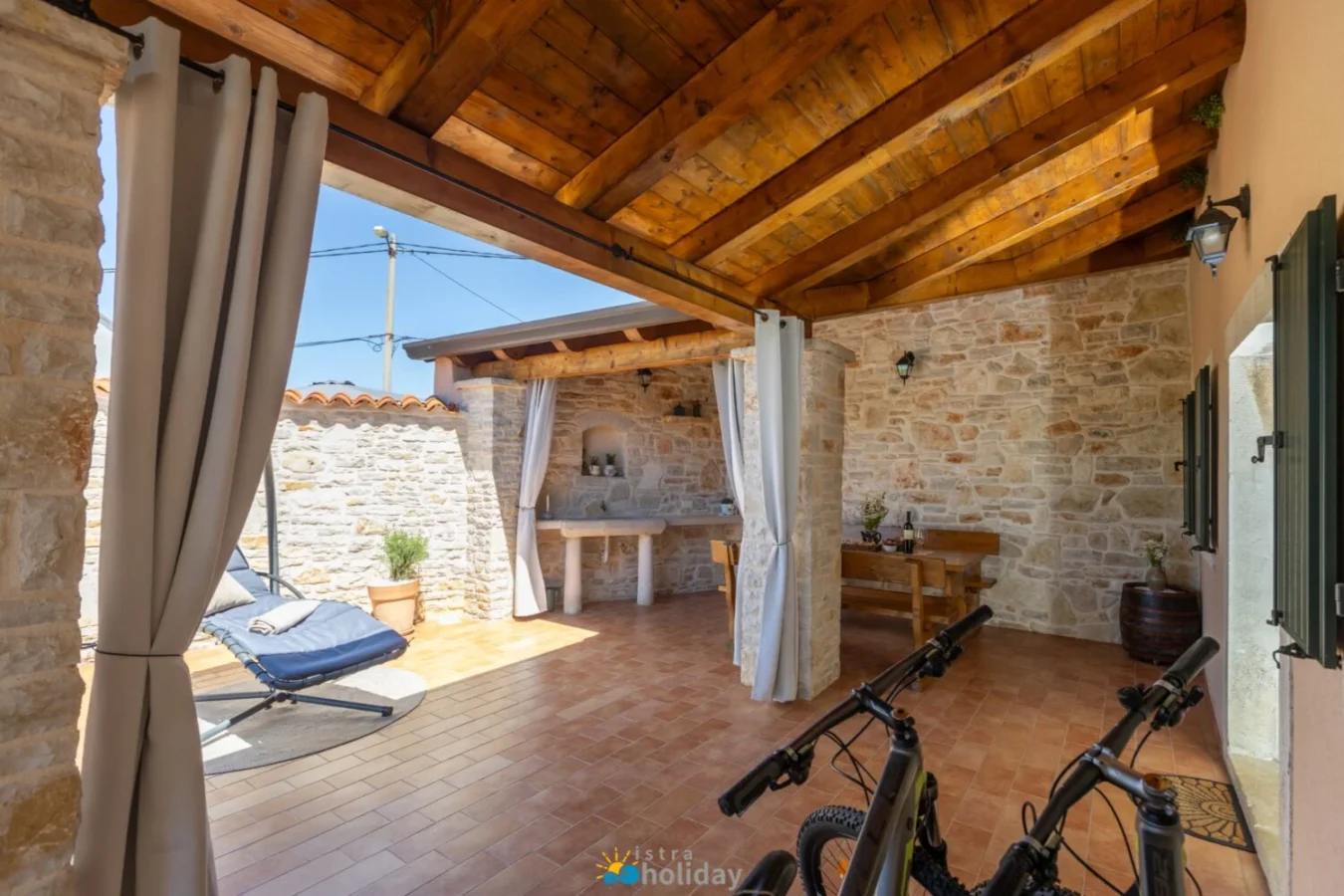Rustic covered patio with stone walls and bikes