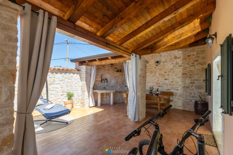 Rustic covered patio with stone walls and bikes
