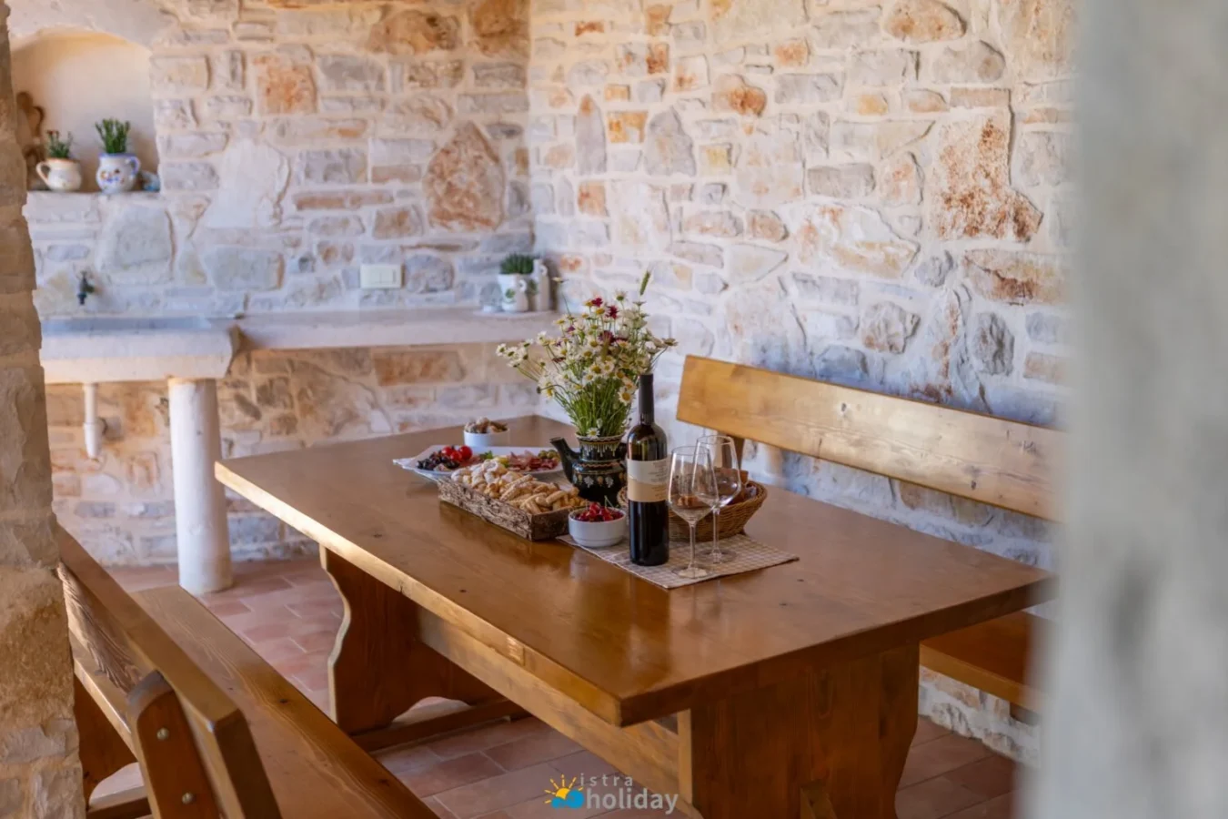 Rustic stone dining area with wine and snacks