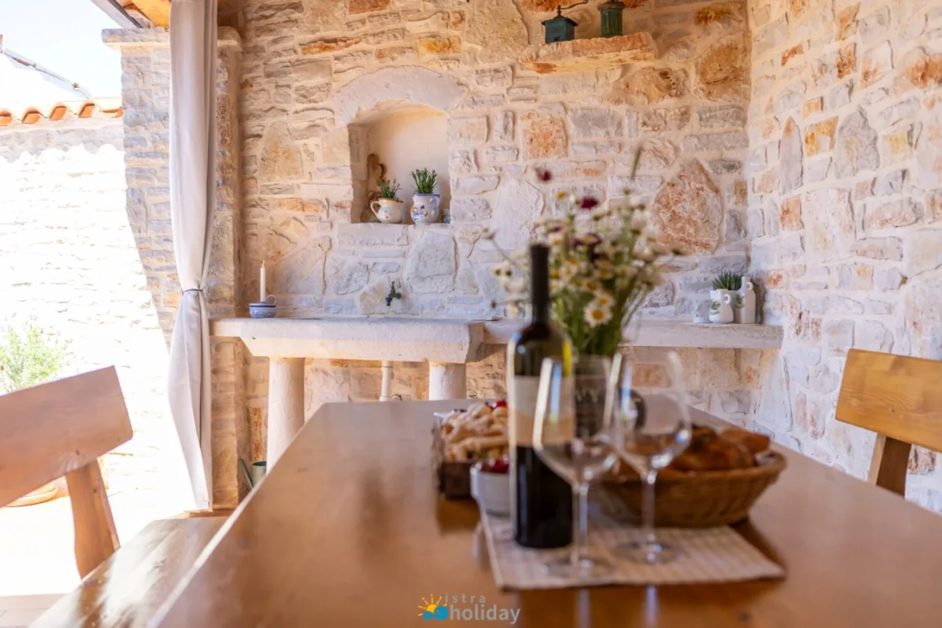 Rustic stone patio dining table with wine and flowers