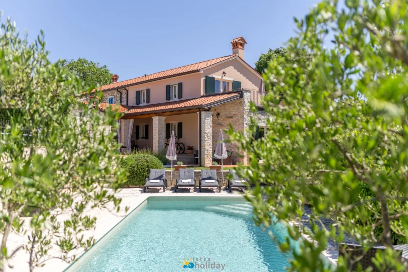 Mediterranean stone villa with pool and lounge chairs
