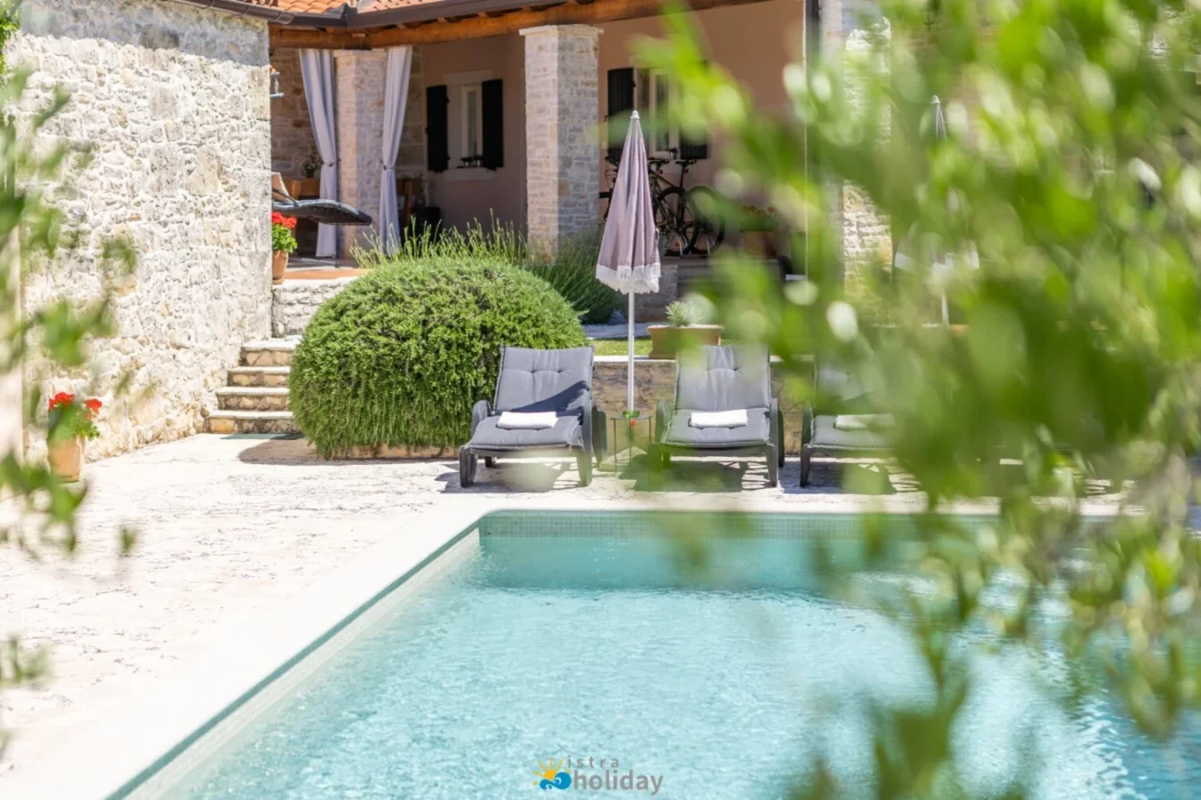 Stone villa patio with pool and lounge chairs