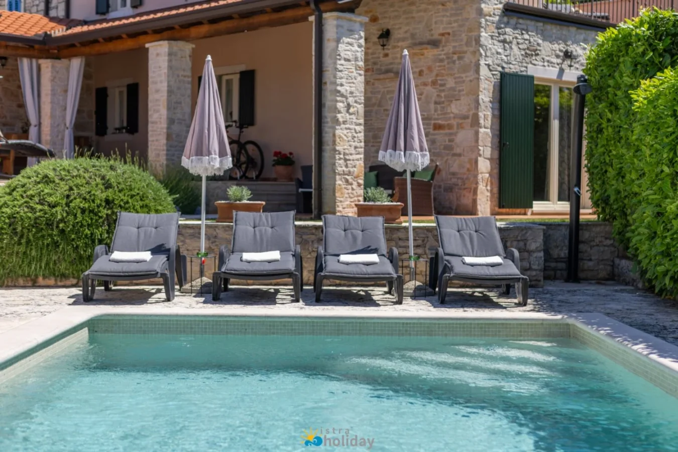 Stone villa with pool and lounge chairs
