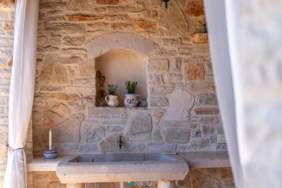 Rustic stone sink with potted plants and candle