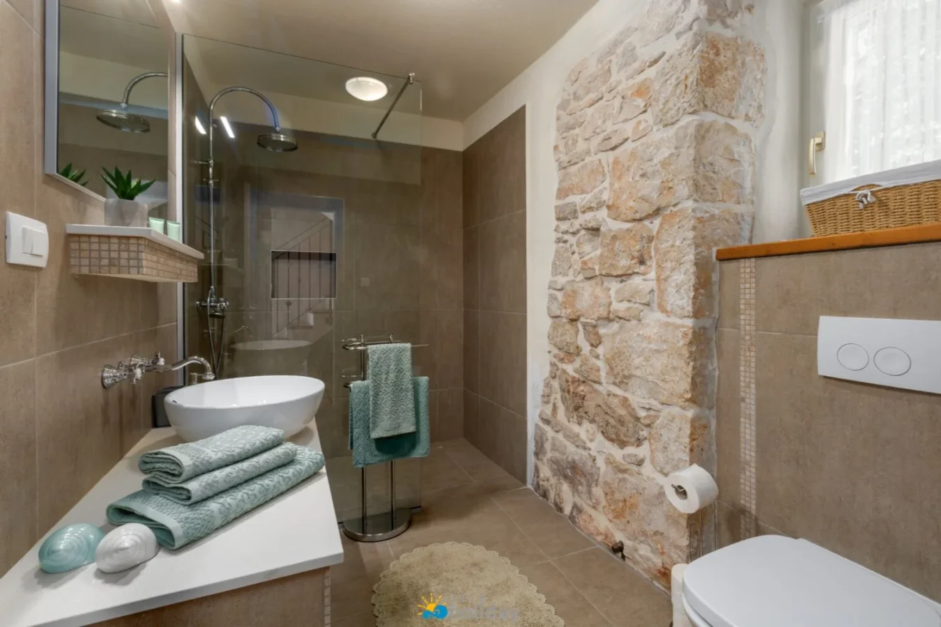 Modern bathroom with stone accent wall and glass shower