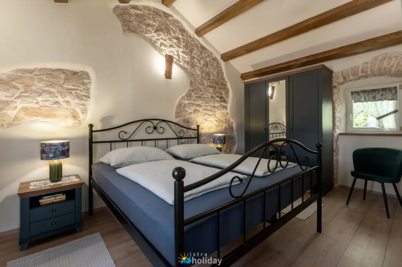 Rustic bedroom with stone walls and metal bed