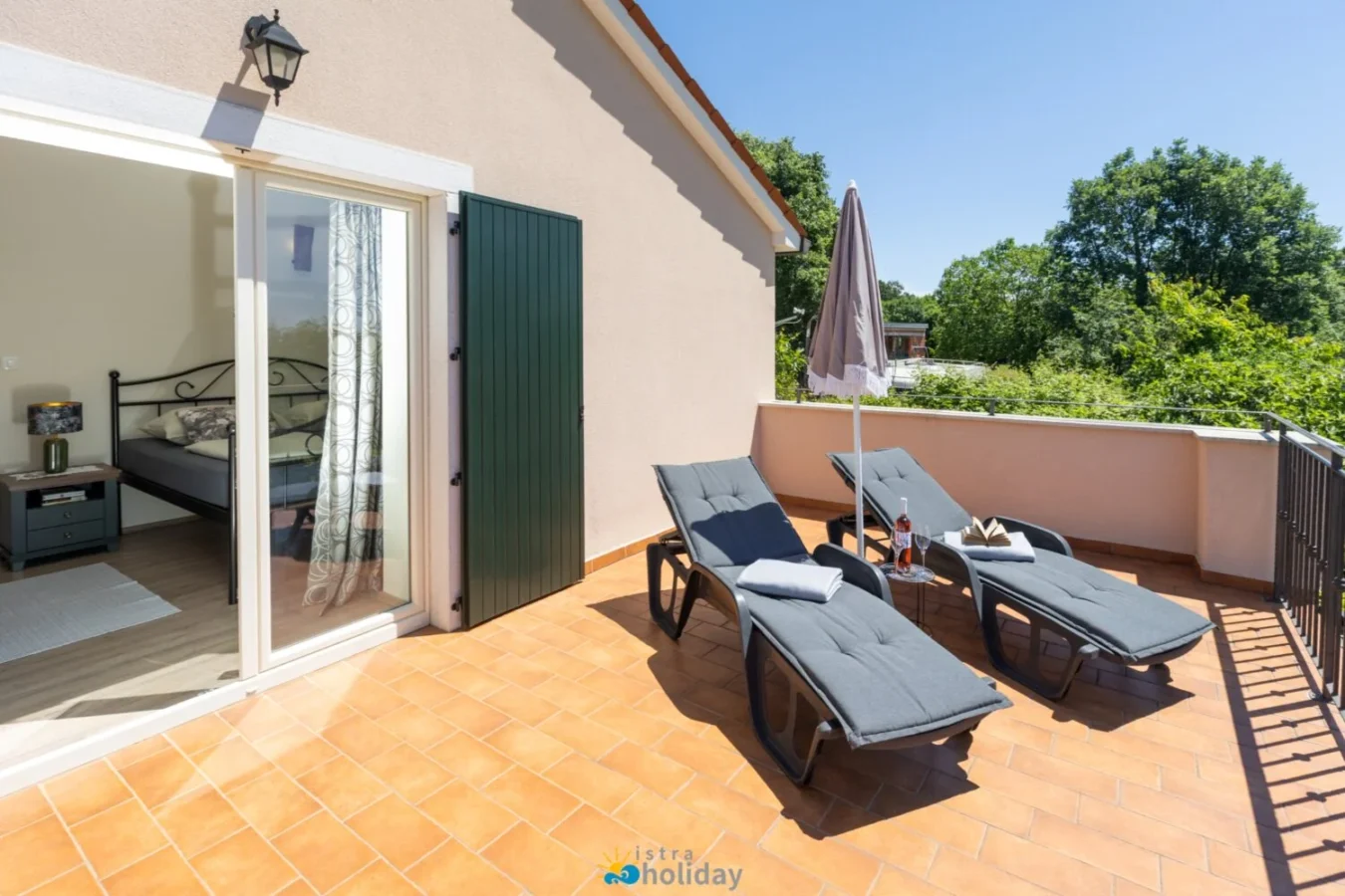 Sunny terrace with lounge chairs and umbrella