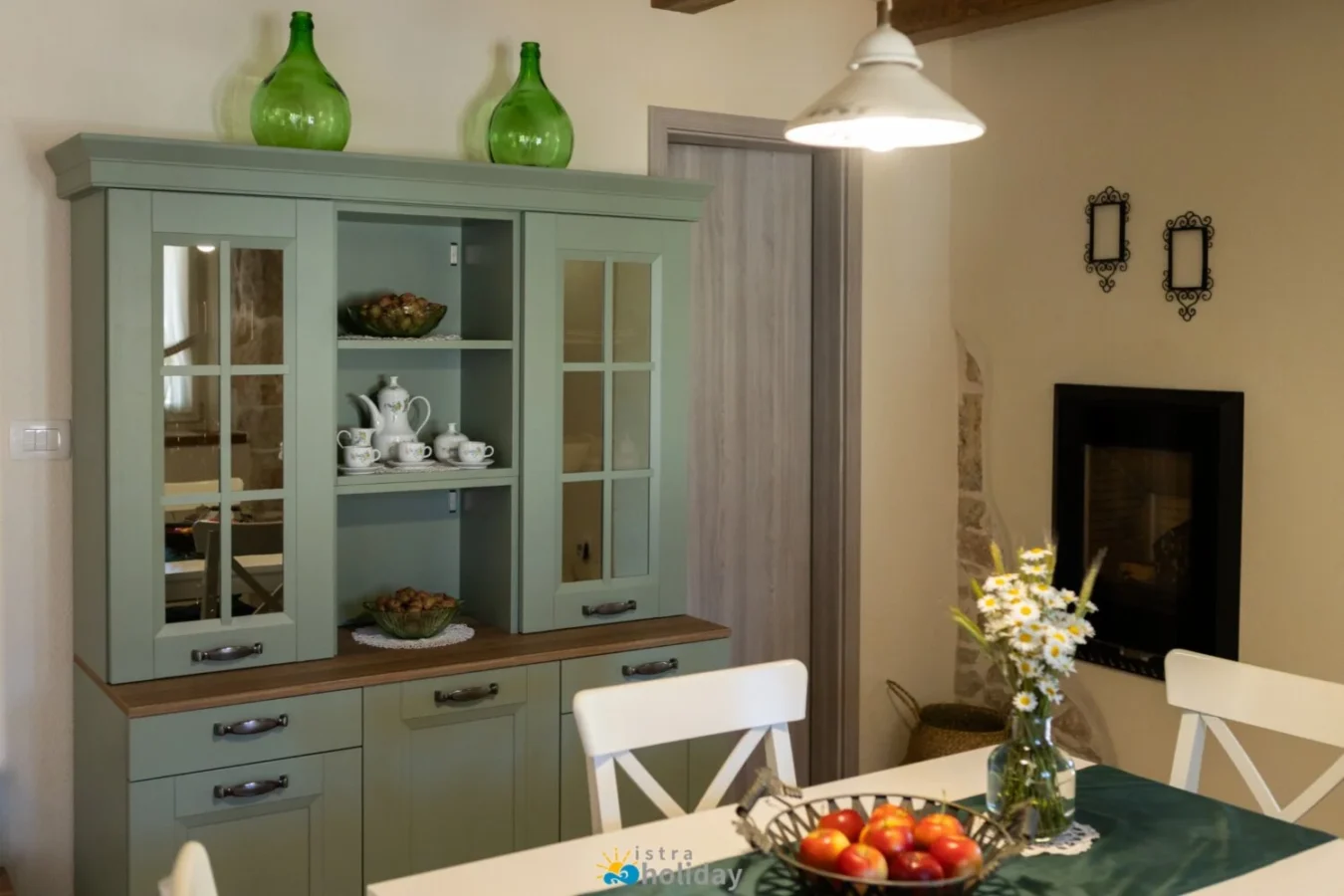 Cozy dining room with green cabinet and fireplace