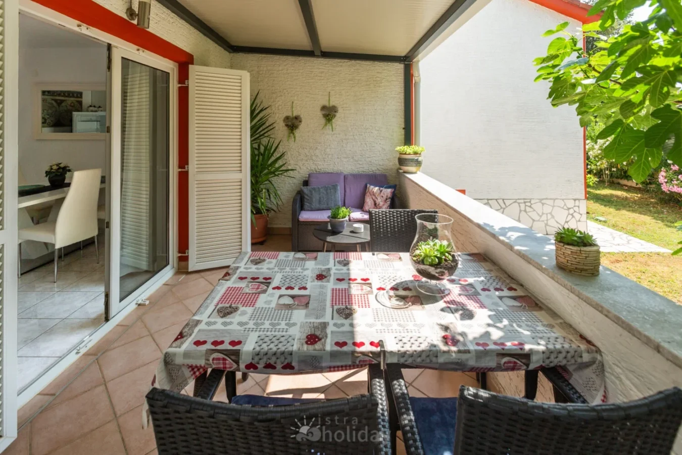 Cozy patio with table, chairs, and sofa seating.