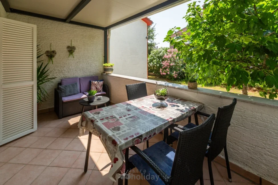 Cozy patio with plants and table setting.