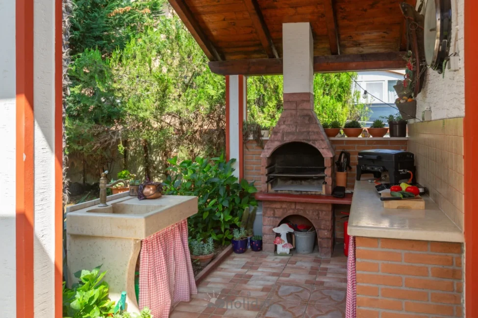 Outdoor kitchen with brick oven and countertop.