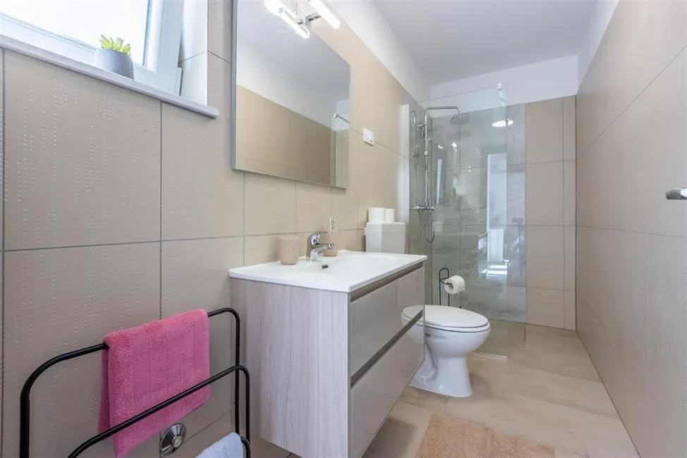 Modern beige bathroom with glass shower and vanity