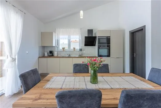 Modern kitchen and dining area with wooden table