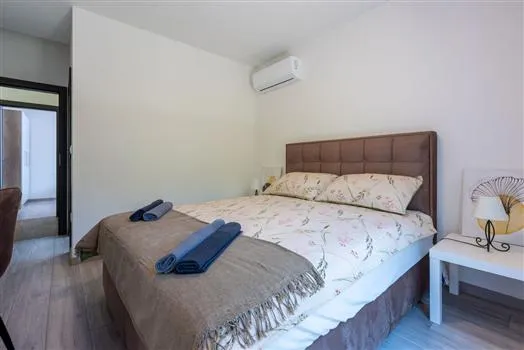 Modern bedroom with double bed and folded towels