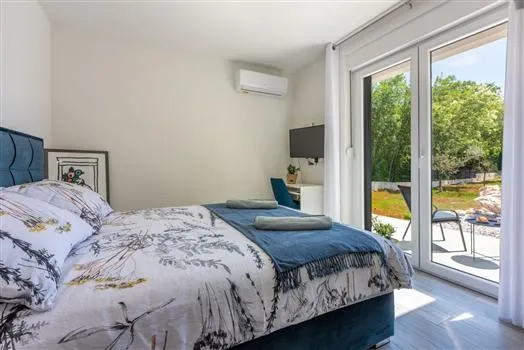 Bright bedroom with garden view and patio doors
