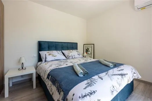 Minimalist bedroom with blue headboard and folded towels