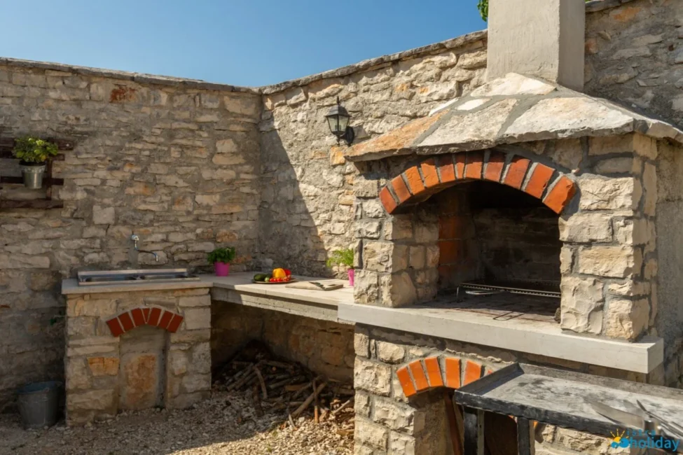 Outdoor stone barbecue with vegetables and herbs