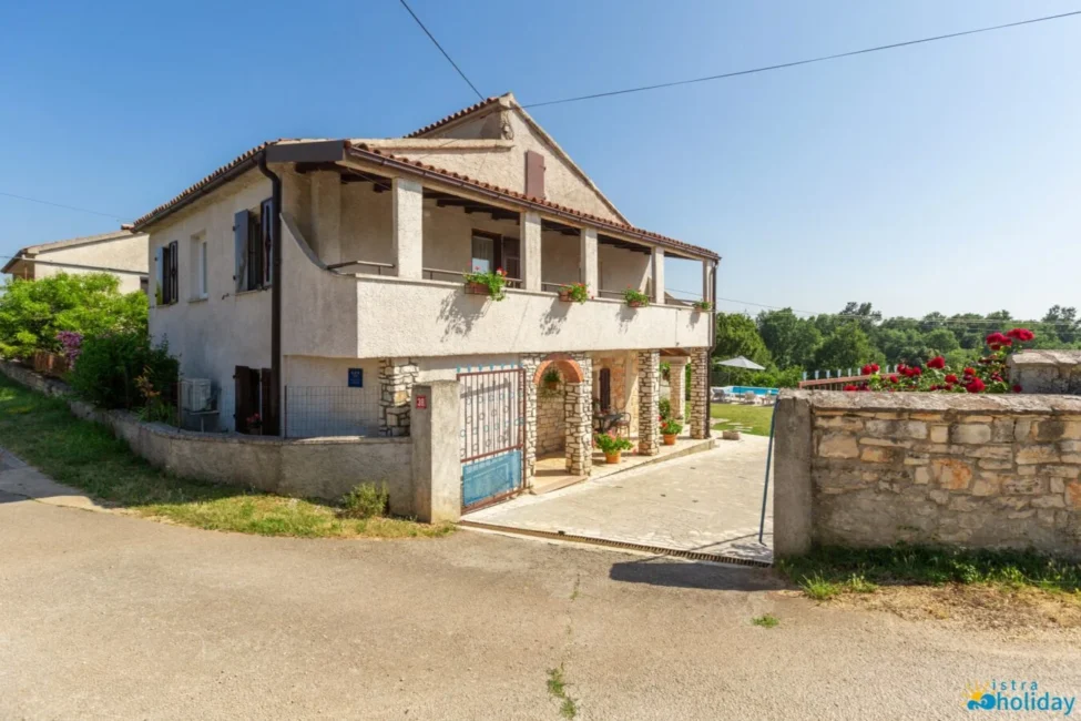 Traditional stone house with balcony and garden.