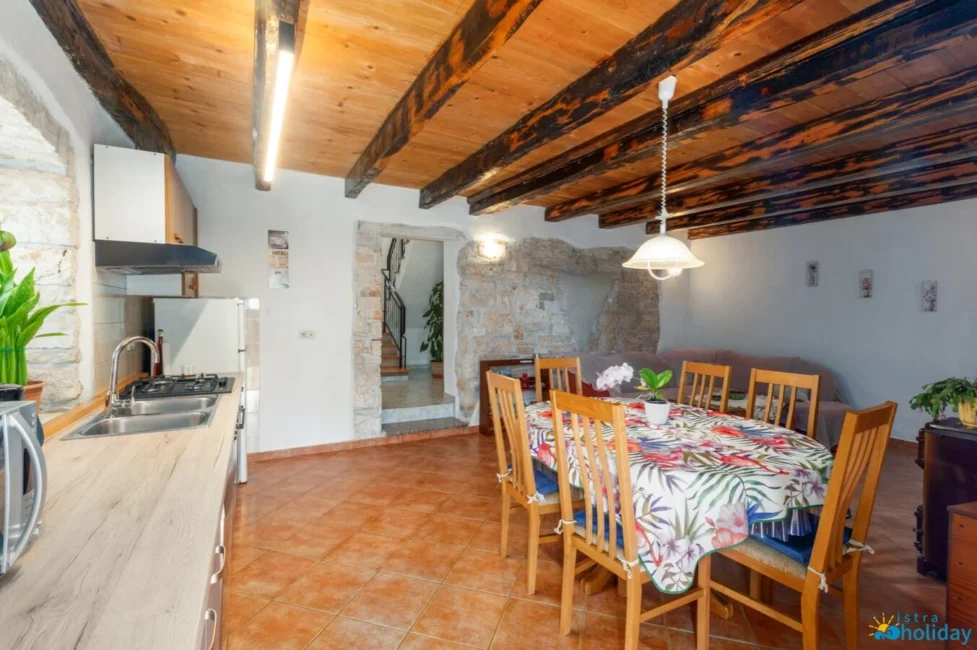 Rustic kitchen and dining area with wooden ceiling.