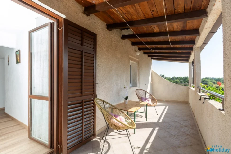 Sunny balcony with chairs and table.