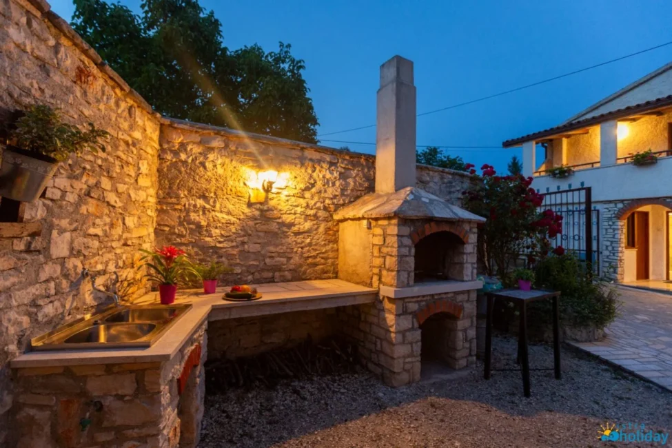 Outdoor stone barbecue area at twilight.