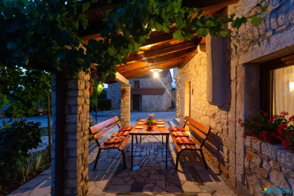 Rustic outdoor dining area with benches at night.