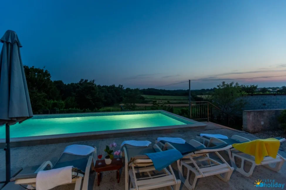 Sunset view with pool and lounge chairs.