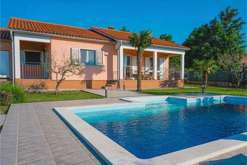 Single-story house with pool and palm trees
