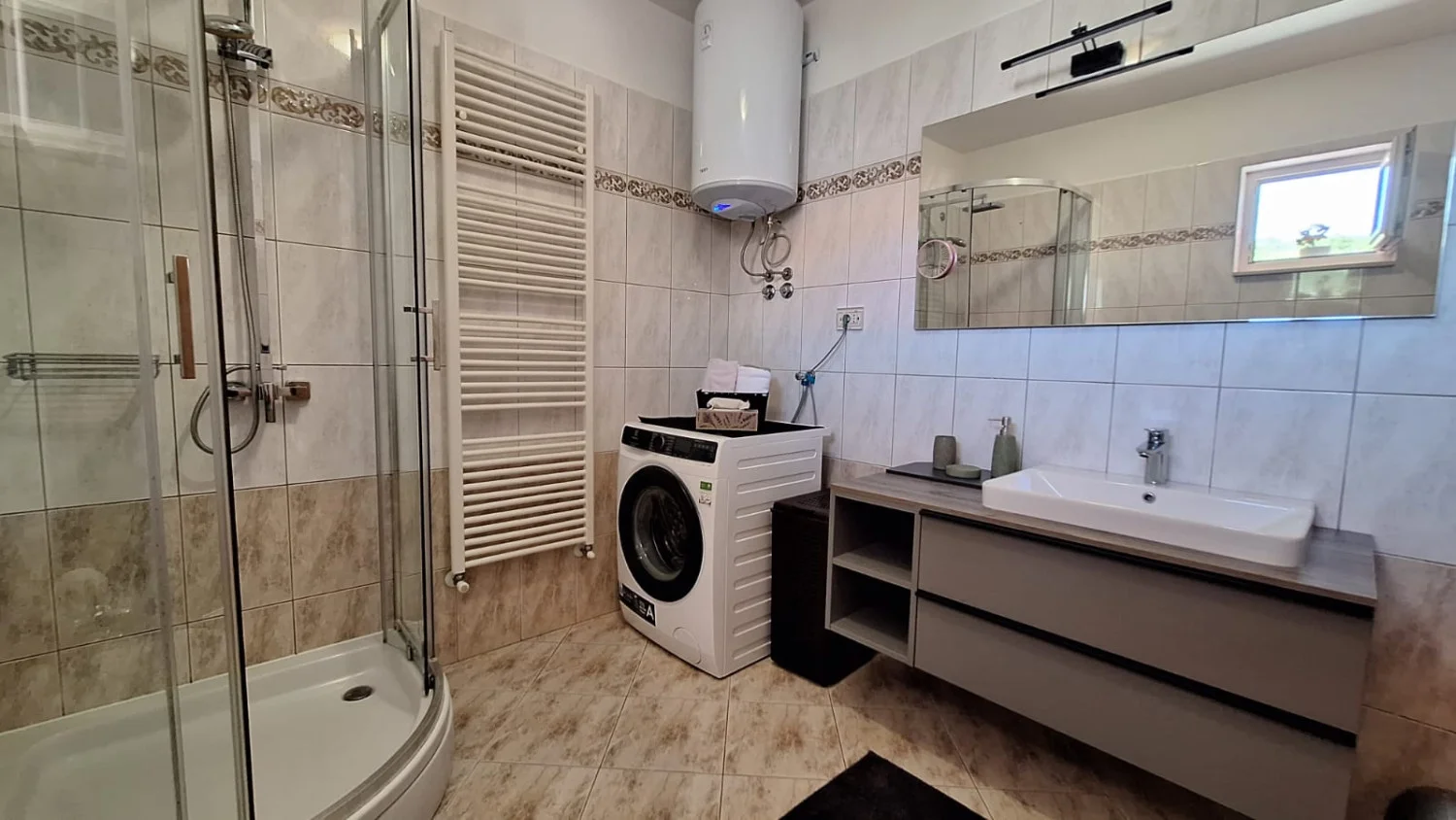 Modern bathroom with shower, sink, and washing machine