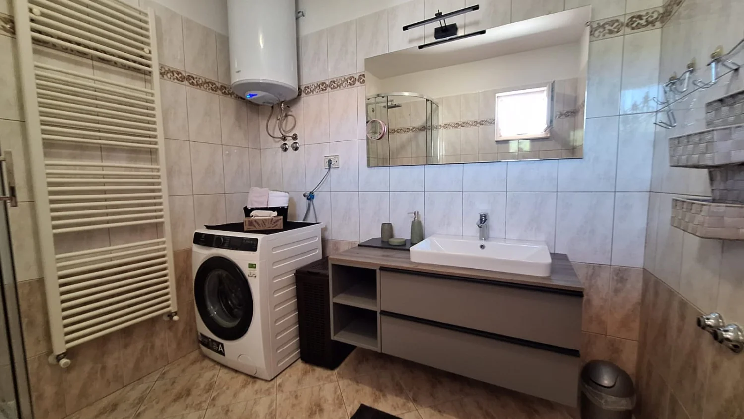 Modern tiled bathroom with sink and washing machine