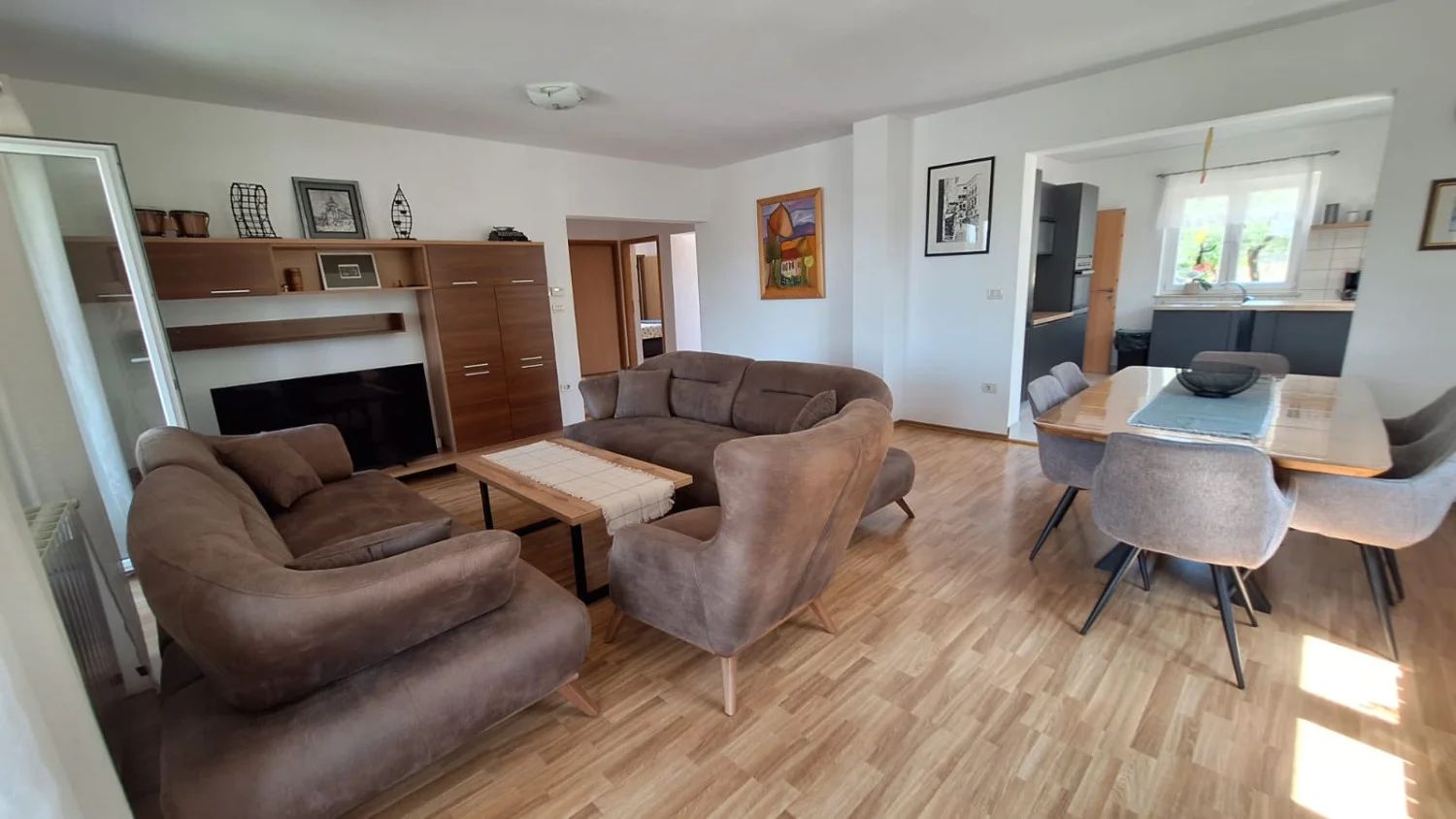 Modern living room with brown sofas and dining area