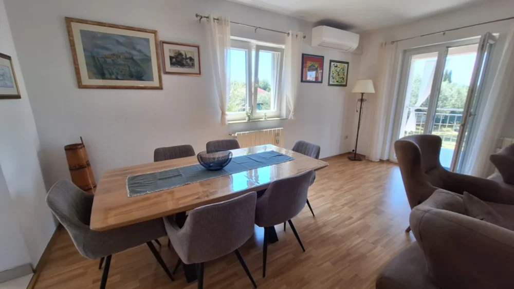 Bright dining room with wooden table and balcony