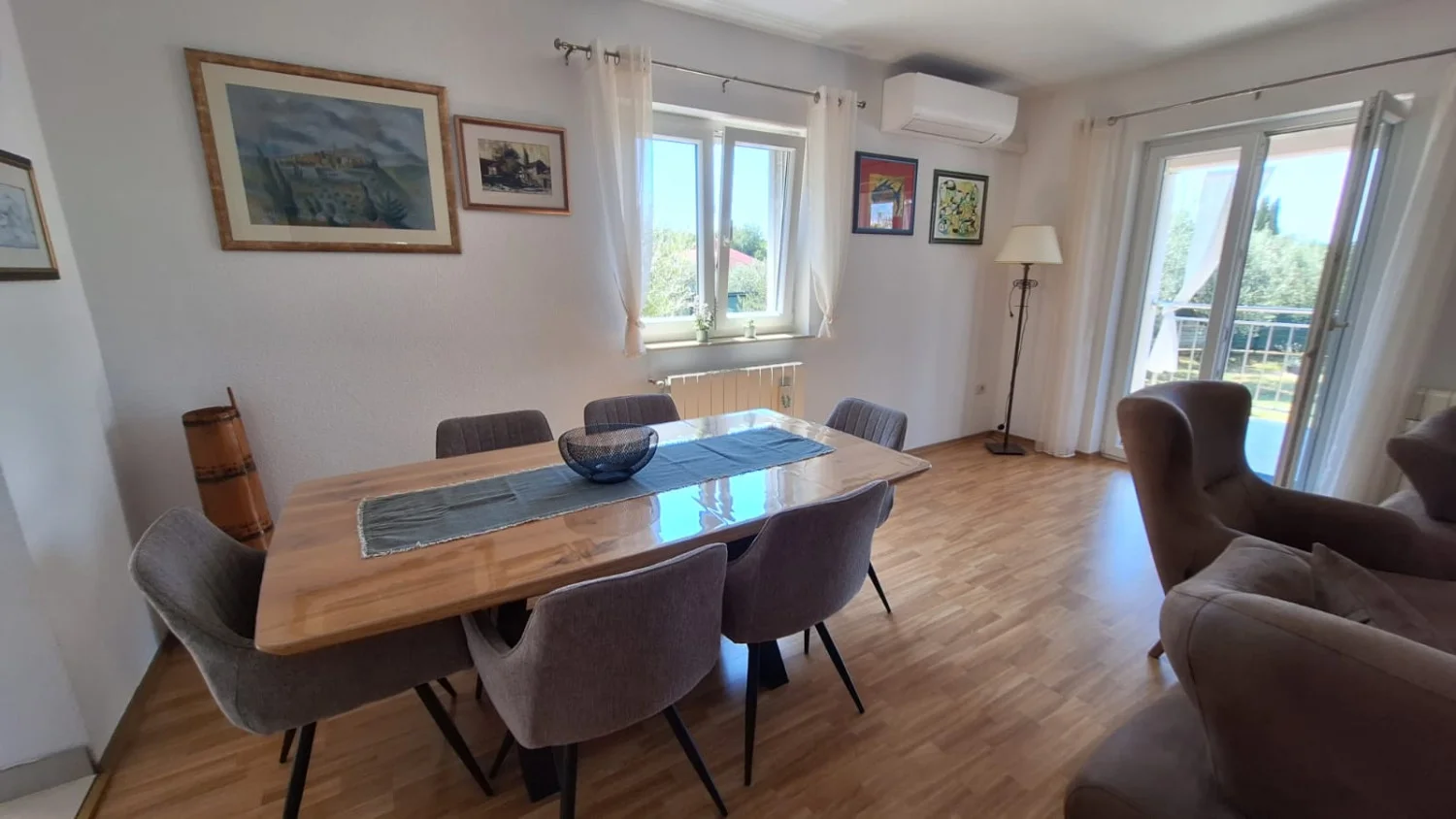 Bright dining room with wooden table and balcony
