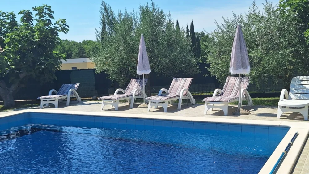Outdoor swimming pool with lounge chairs and umbrellas