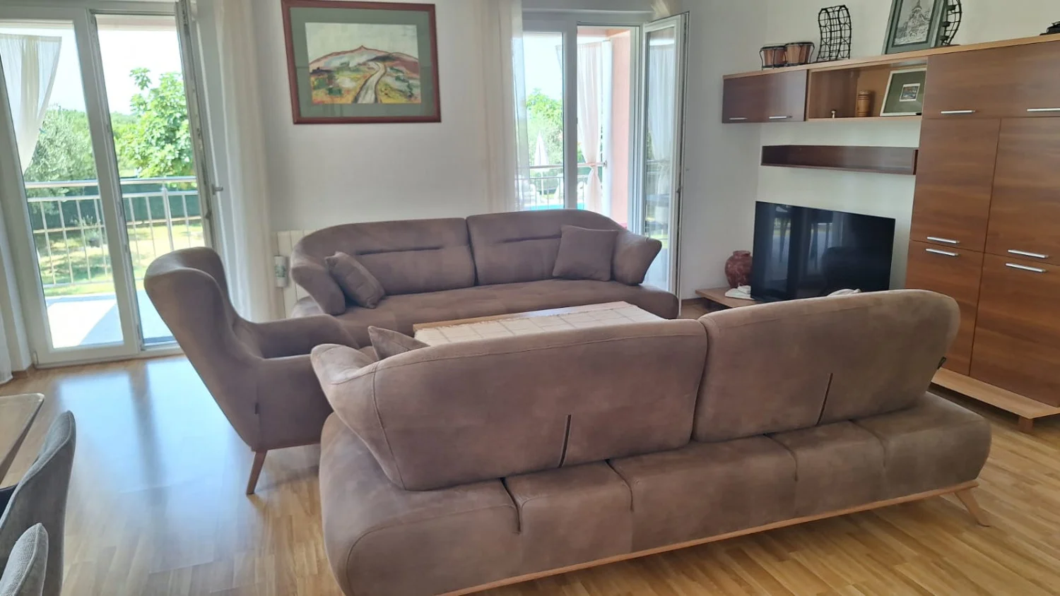 Modern living room with brown sofas and balcony