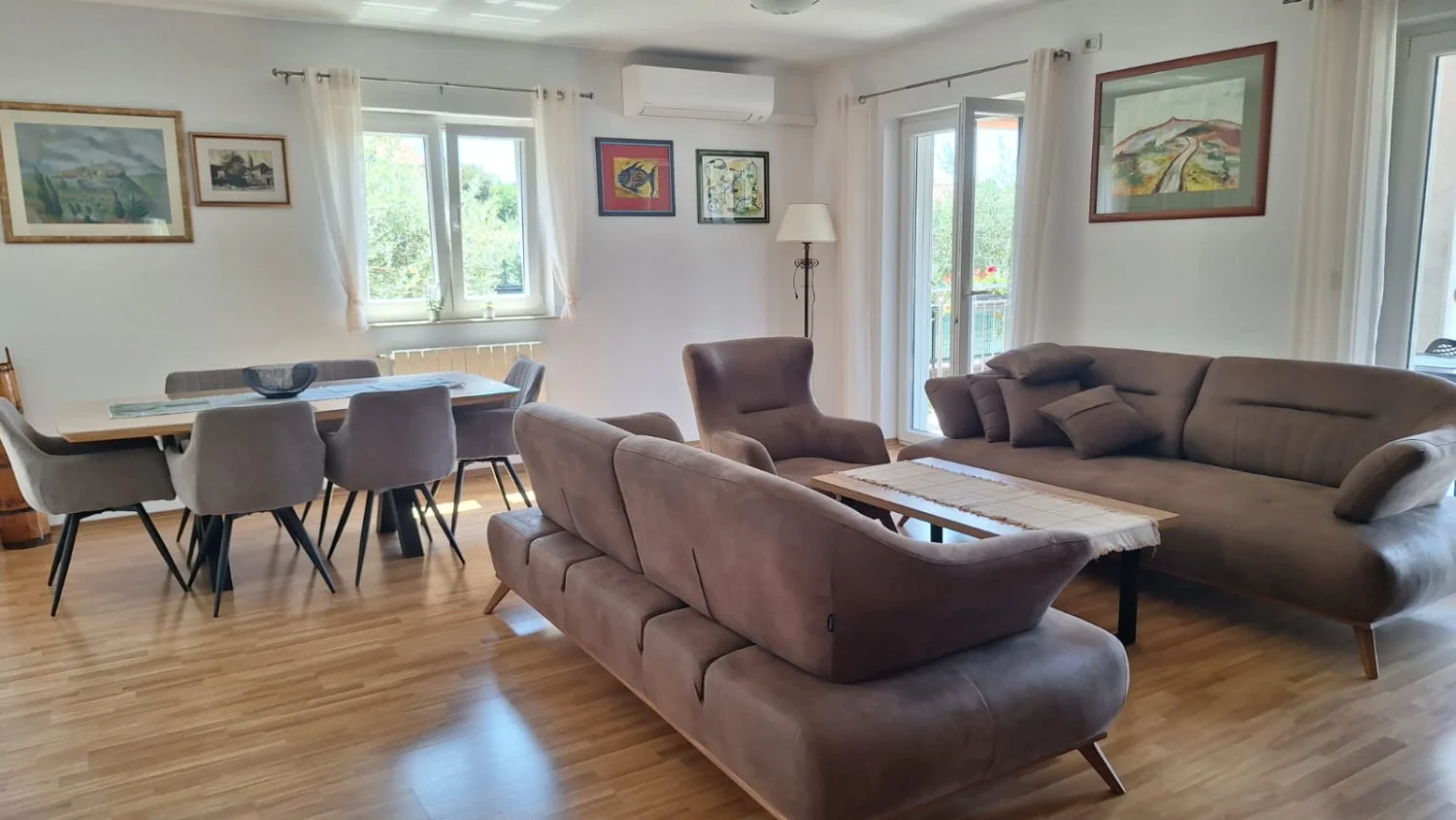 Modern living and dining room with brown sofas
