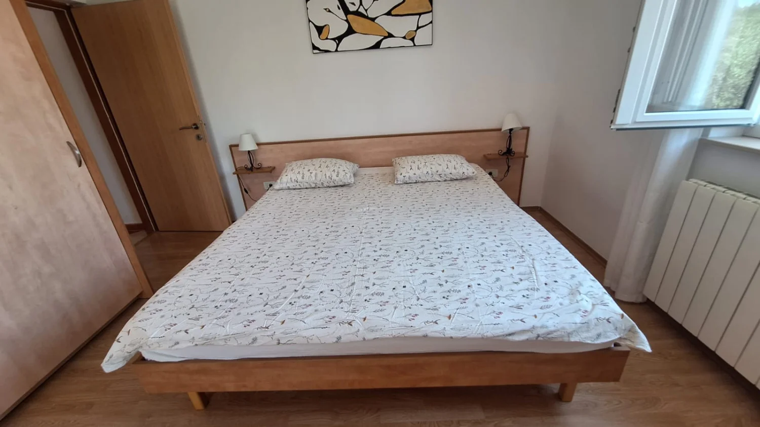 Minimalist bedroom with wooden bed and wardrobe