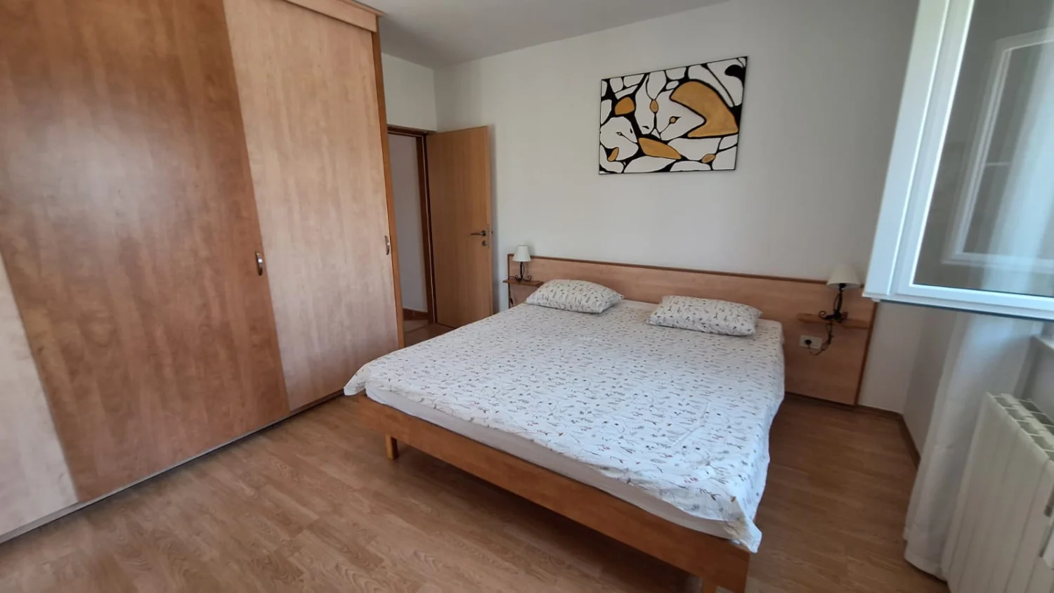 Minimalist bedroom with wooden bed and wardrobe
