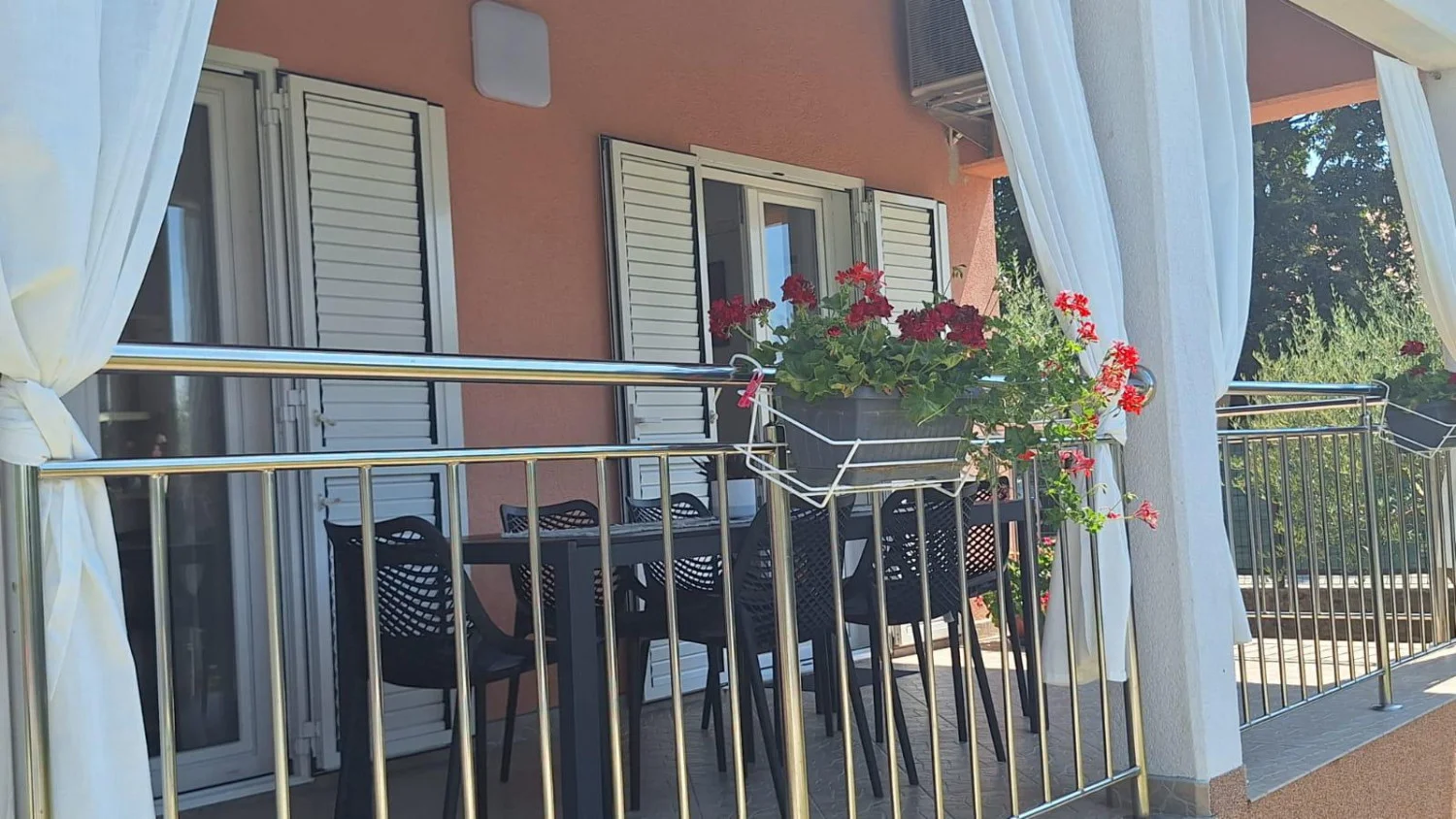 Balcony with red flowers and outdoor seating