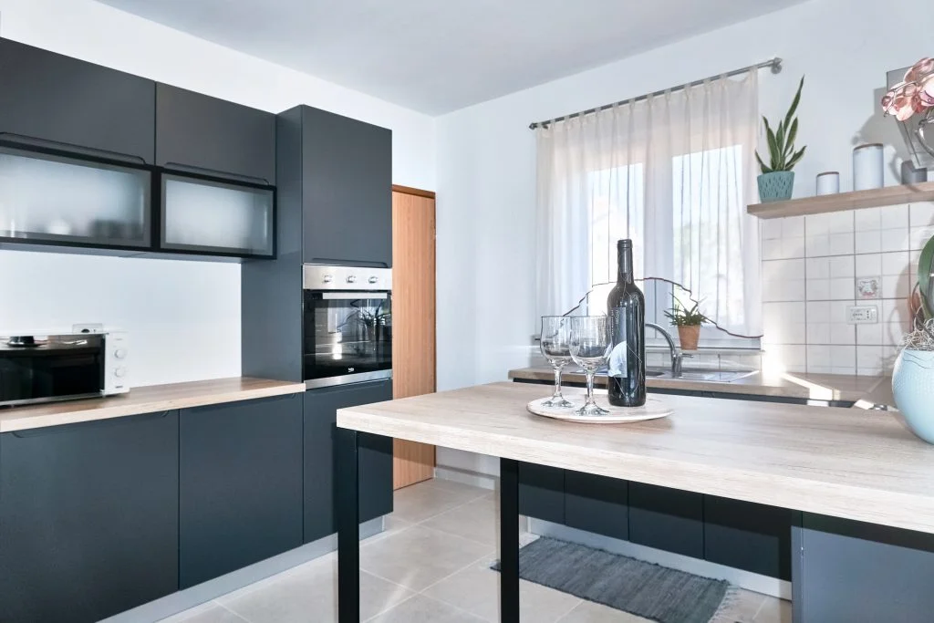 Modern kitchen with dark cabinets and wine glasses