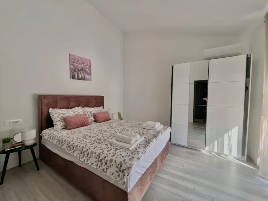 Bright modern bedroom with double bed and wardrobe