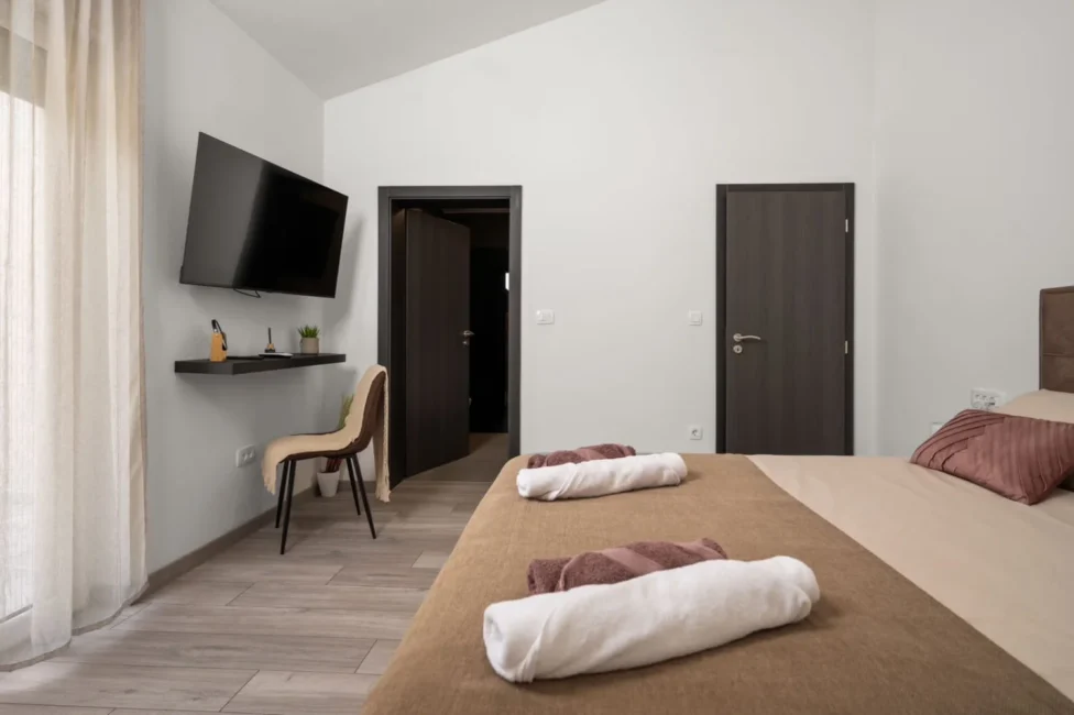Modern minimalist bedroom with bed and wall-mounted TV