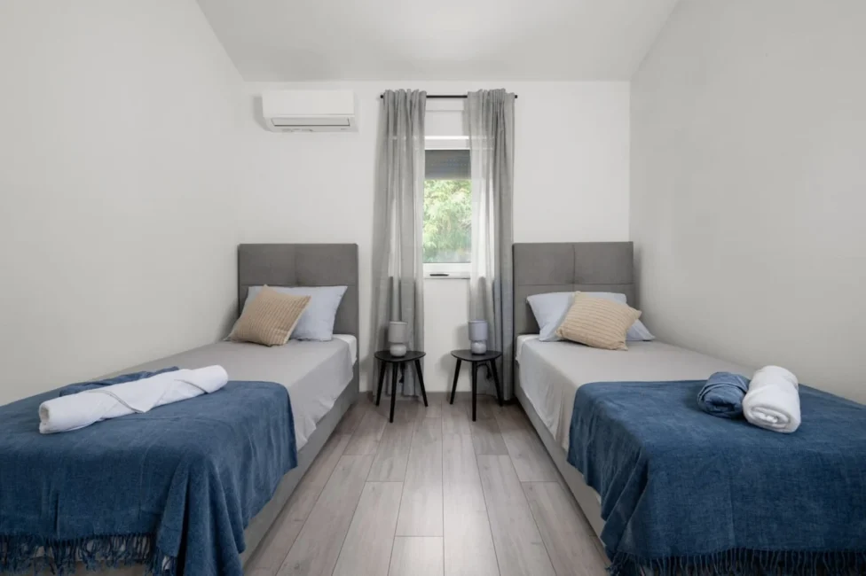 Minimalist bedroom with two twin beds and window